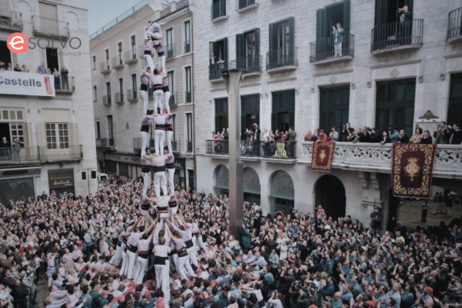 Castellers actuant durant les Fires de Sant Narcís a Girona, amb el logo d'Esolvo Comunica